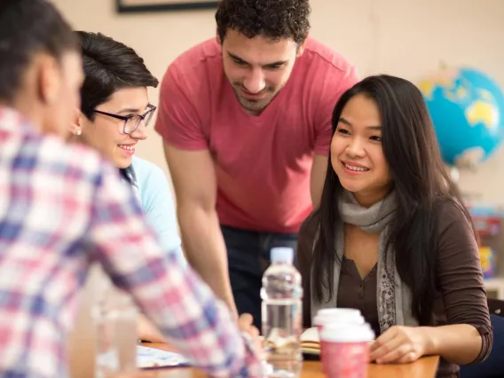 four students studying together at desk