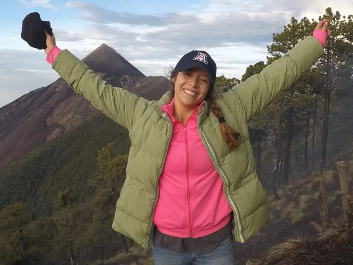 woman with hands up on a mountain in Latin America