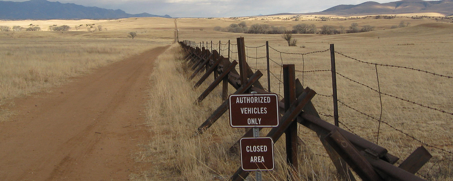 Wire fence along U.S. Mexico Border with signage reading "Closed Area" 